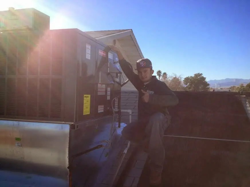HVAC technician performing Boiler Repair on a rooftop unit in DeForest